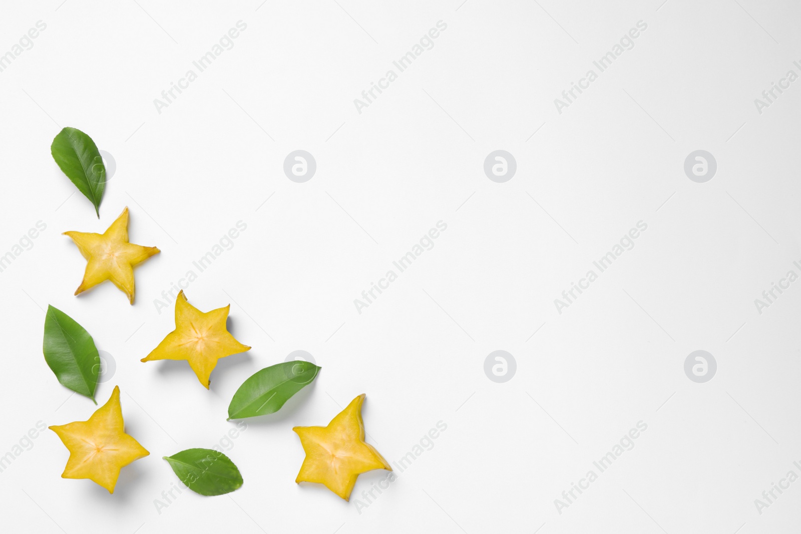 Photo of Flat lay composition with cut carambola on white background. Space for text