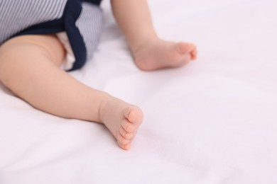 Photo of Newborn baby lying on white blanket, closeup. Space for text