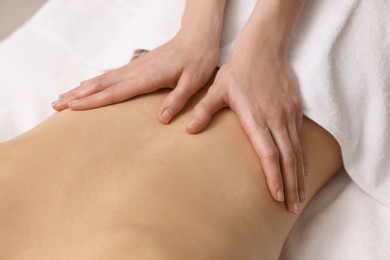 Photo of Woman receiving back massage on couch in spa salon, closeup
