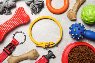 Flat lay composition with dog collar, toys and food on grey background