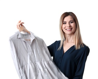 Young woman holding hanger with dress in plastic bag on white background. Dry-cleaning service