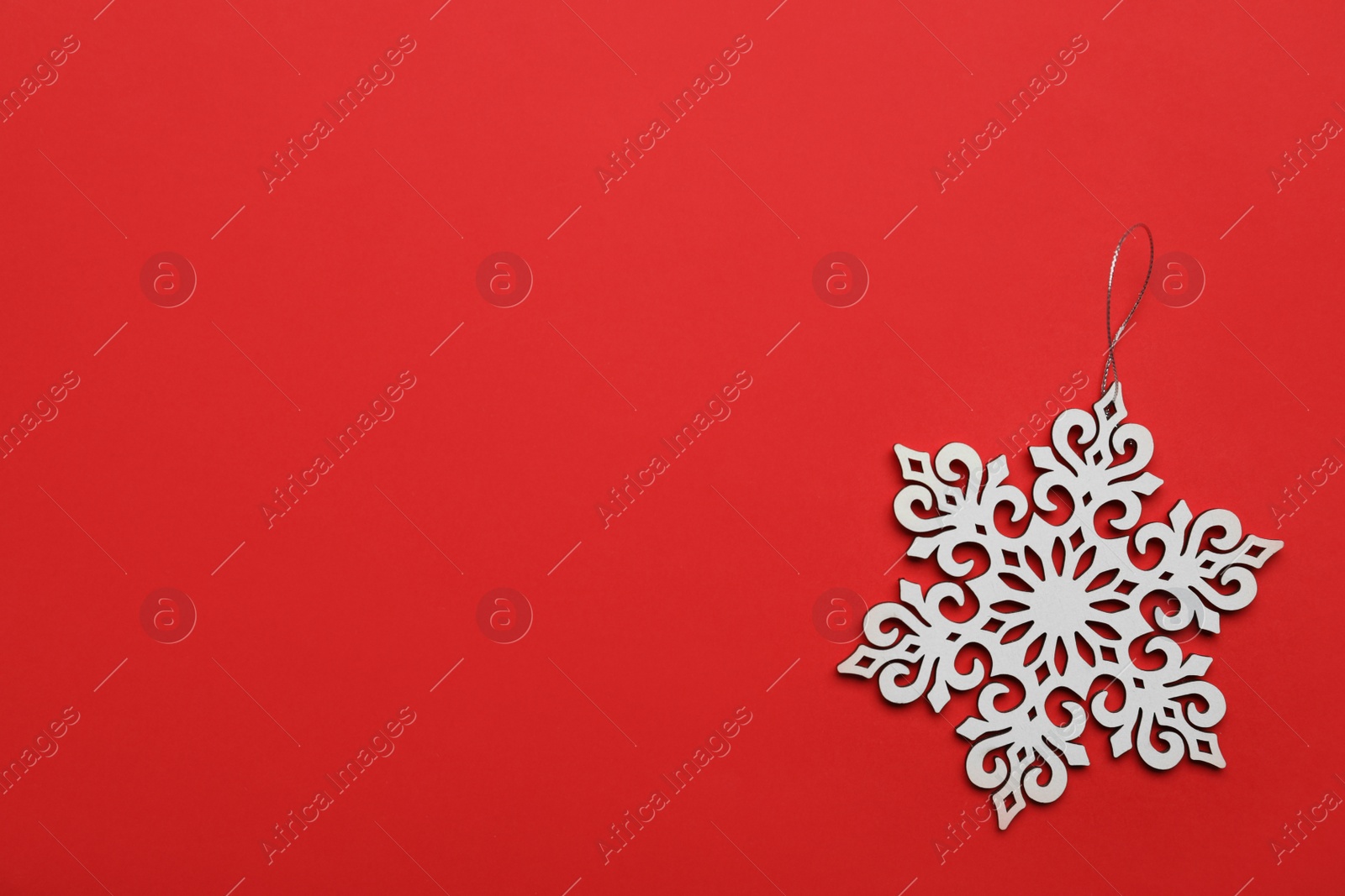Photo of Beautiful decorative snowflake on red background, top view. Space for text