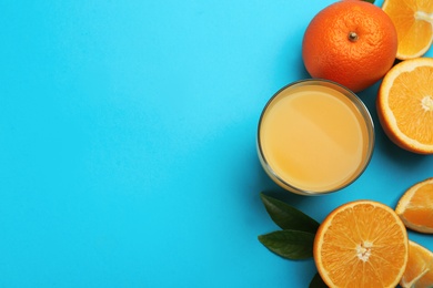 Photo of Delicious orange juice and fresh fruits on light blue background, flat lay. Space for text