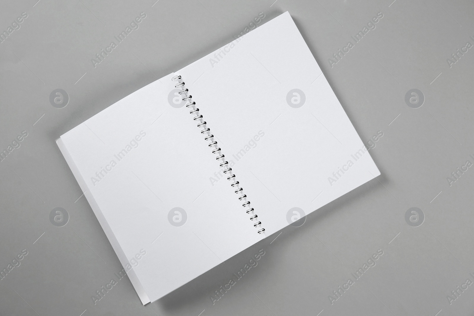 Photo of Open blank notebook on grey background, top view. Mockup for design