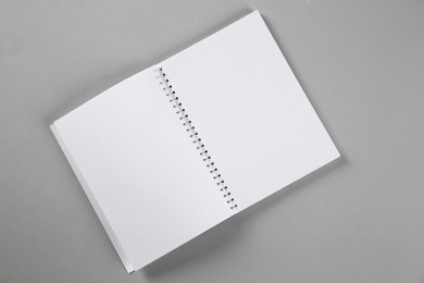 Photo of Open blank notebook on grey background, top view. Mockup for design