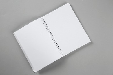 Open blank notebook on grey background, top view. Mockup for design