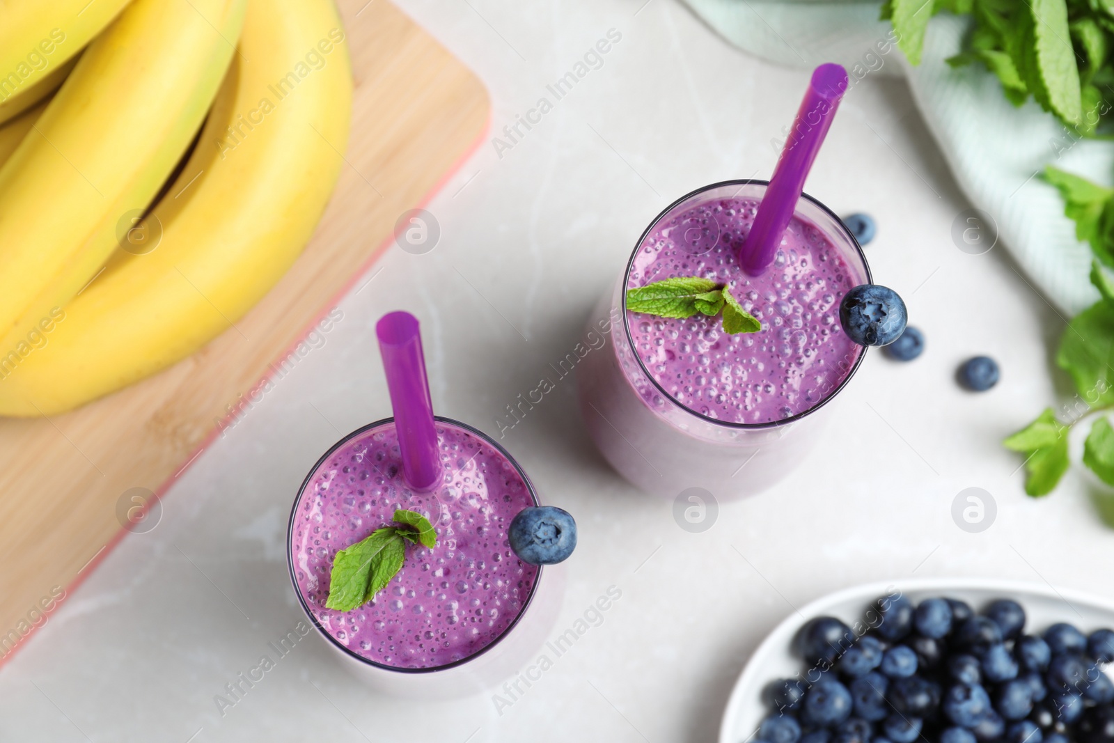 Photo of Flat lay composition with delicious blueberry smoothie on light marble table