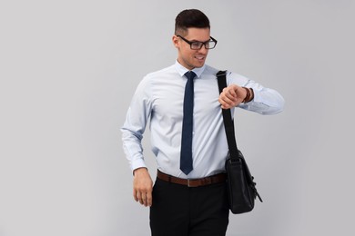 Businessman with stylish leather briefcase on light background