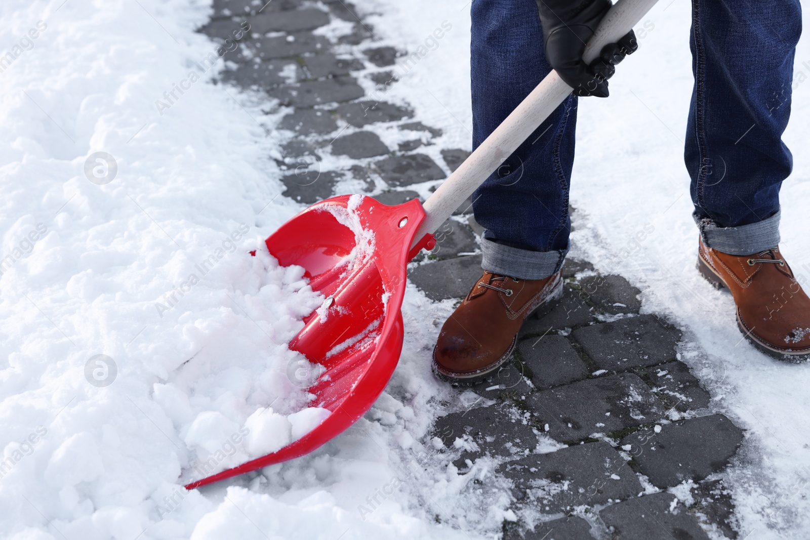 Photo of Man removing snow with shovel outdoors, closeup