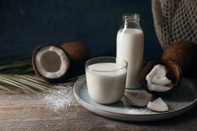 Composition with coconut milk on wooden table, space for text