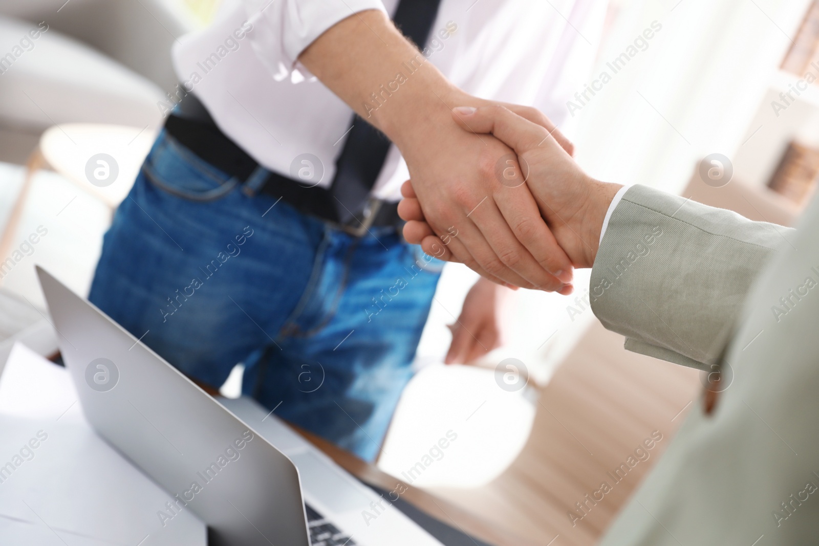 Photo of Business partners shaking hands after meeting, closeup