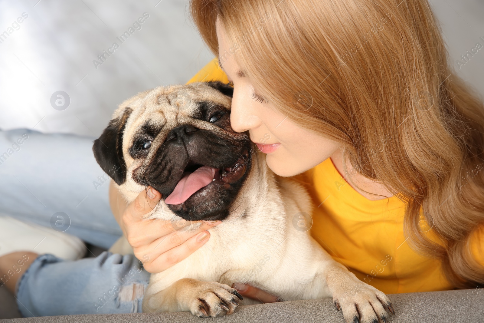 Photo of Woman with cute pug dog at home. Animal adoption