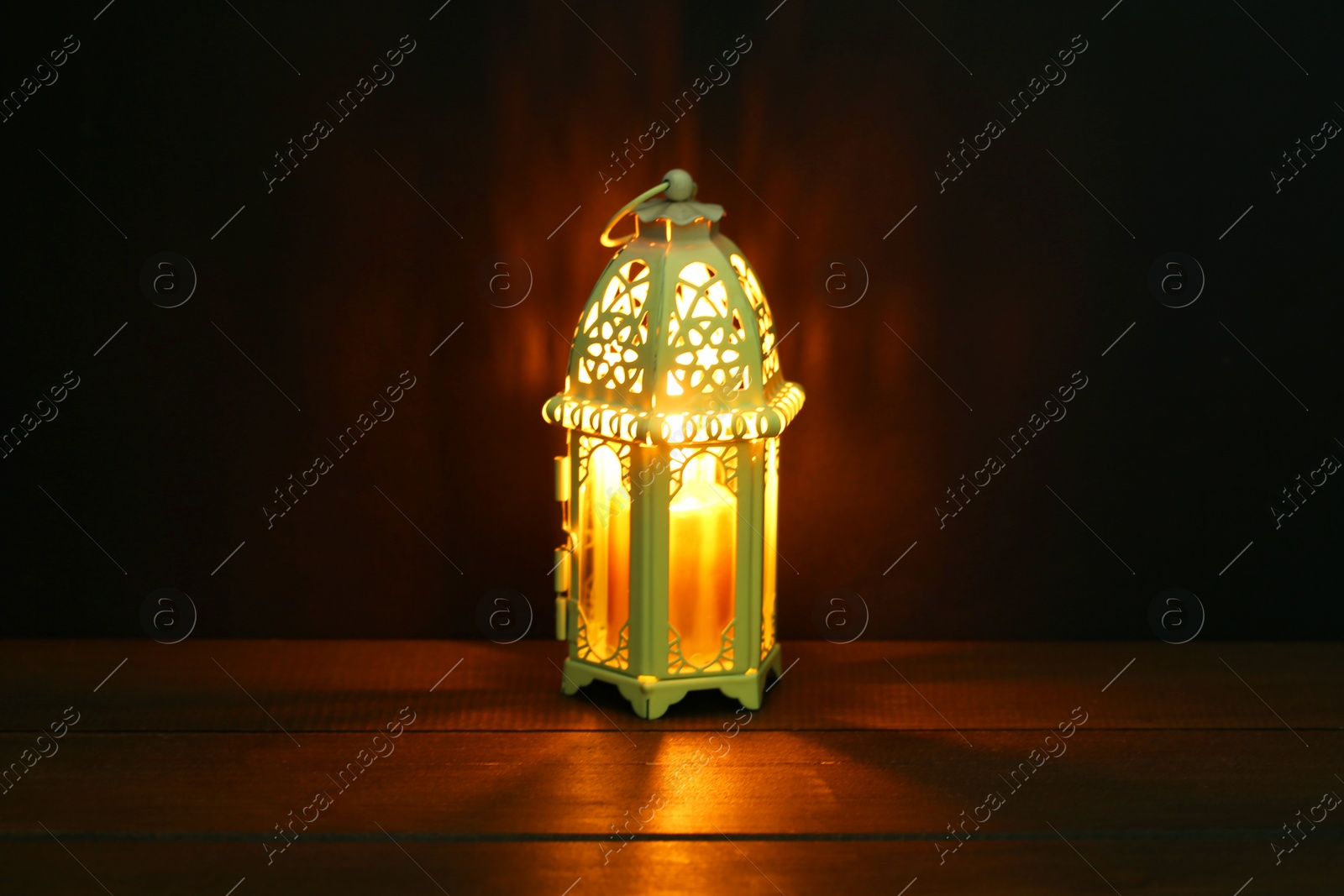 Photo of Decorative Arabic lantern on table against dark background