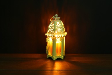 Photo of Decorative Arabic lantern on table against dark background