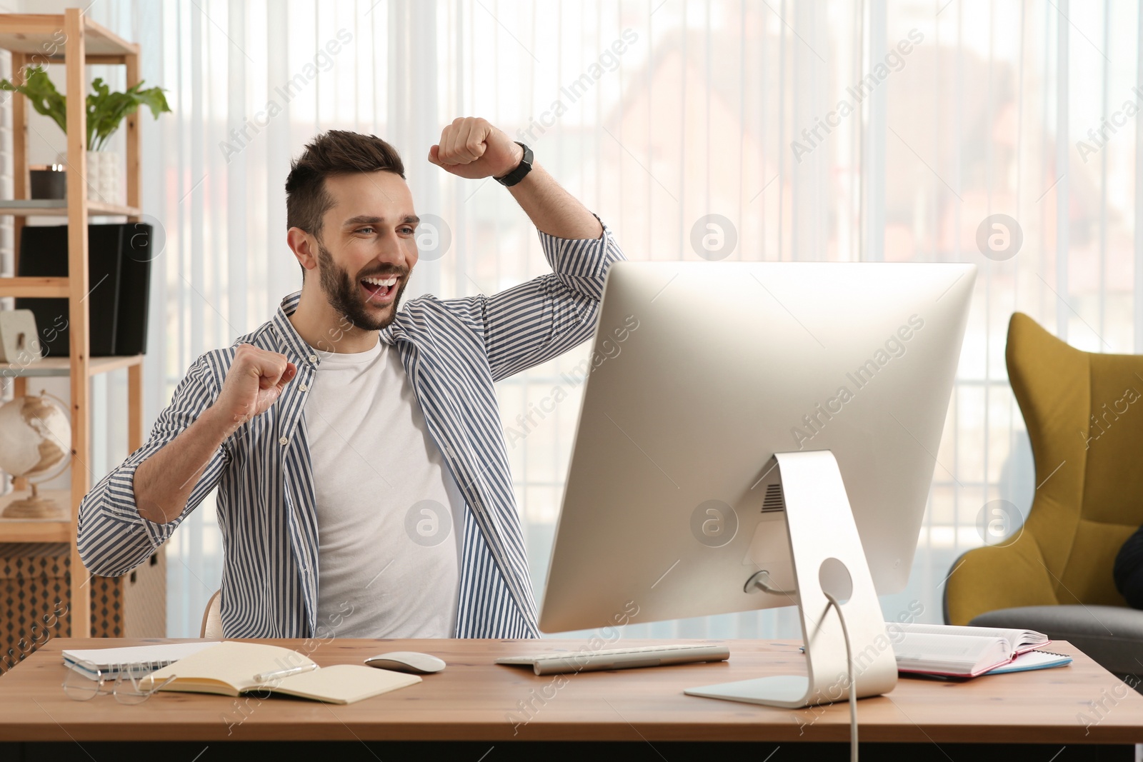 Photo of Online test. Happy man studying with computer at home