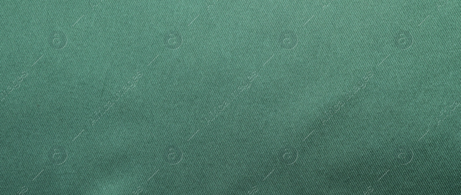 Photo of Texture of green silk fabric as background, top view