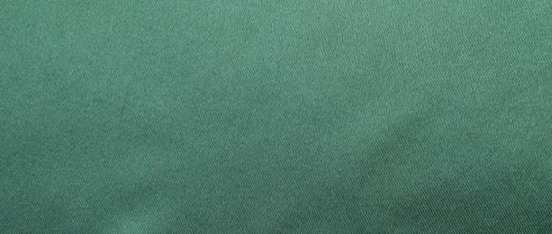 Photo of Texture of green silk fabric as background, top view