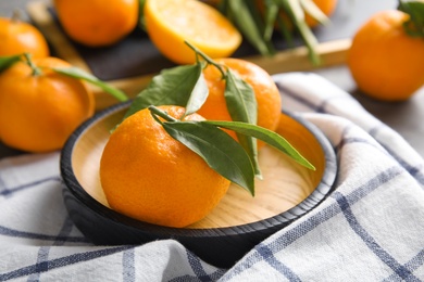 Plate with tasty ripe tangerines on table