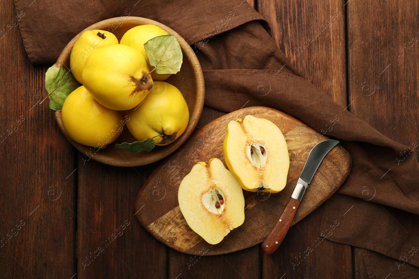 Photo of Tasty ripe quince fruits and knife on wooden table, flat lay