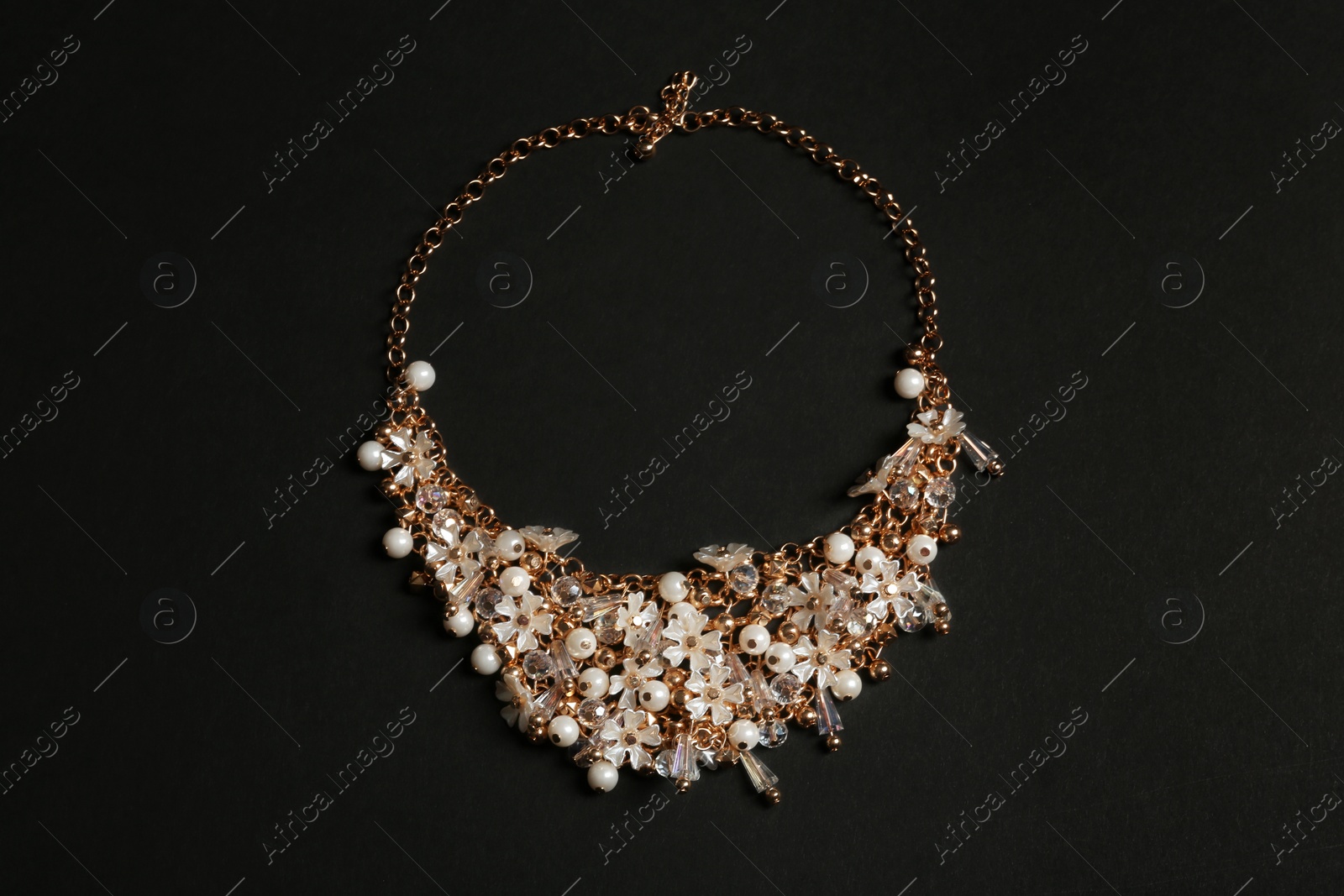 Photo of Stylish necklace with gemstones on black background, top view. Luxury jewelry