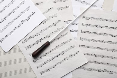 Conductor's baton on sheet music, top view