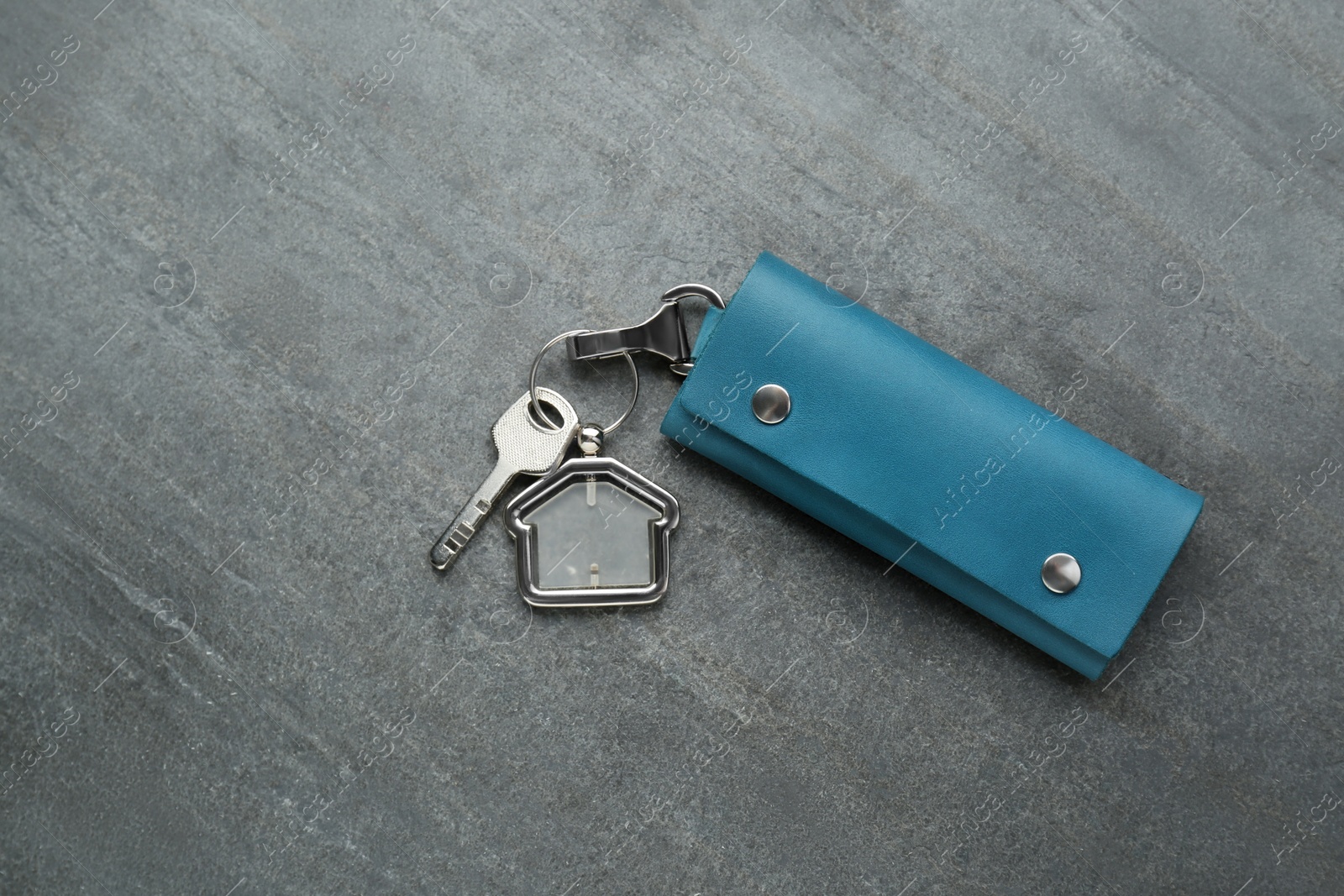 Photo of Leather case with keys on grey table, top view. Space for text