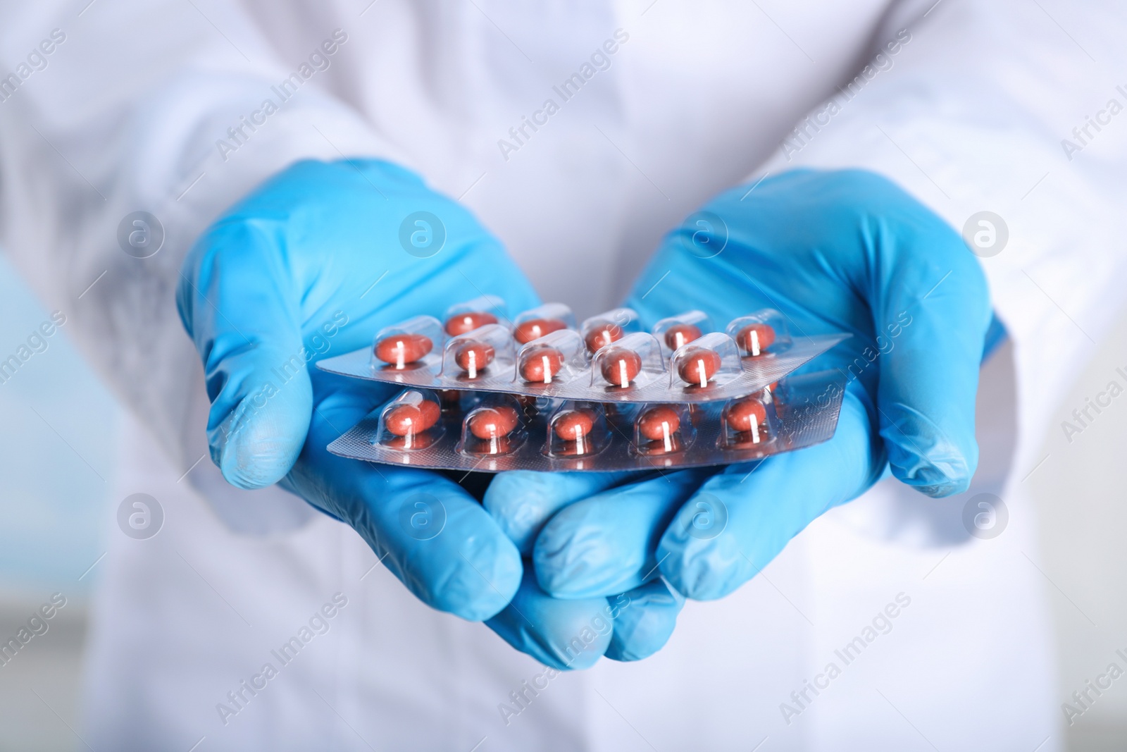 Photo of Doctor holding red pills, closeup. Anemia treatment