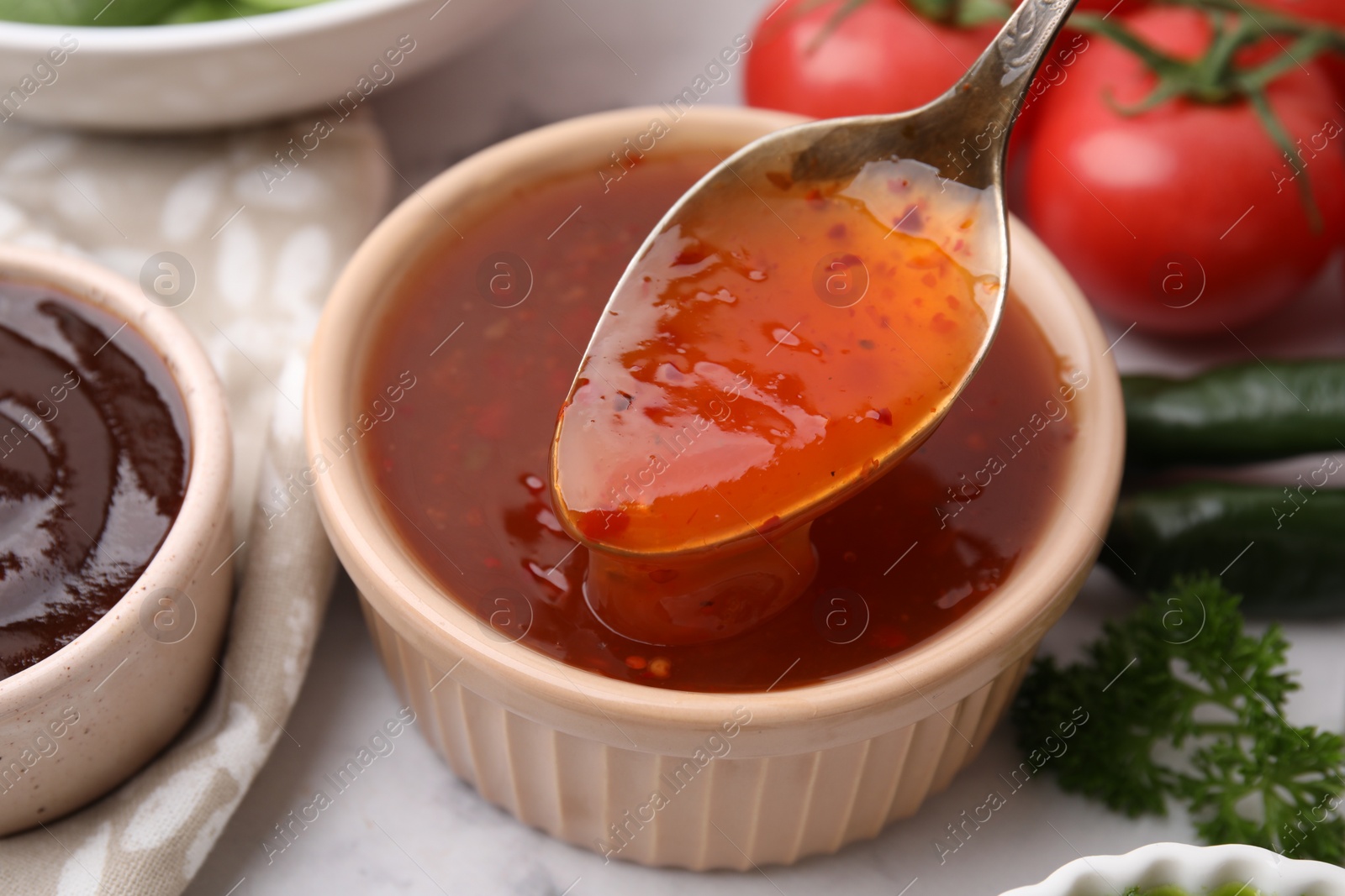 Photo of Taking homemade marinade from bowl at table, closeup