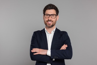 Photo of Happy real estate agent in glasses on grey background