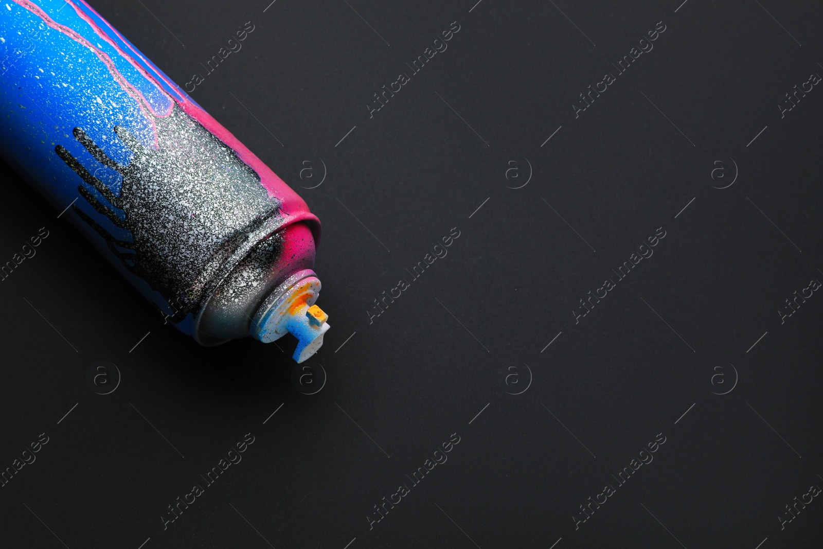 Photo of Used can of spray paint on black background, space for text. Graffiti supply