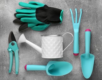 Flat lay composition with watering can and gardening tools on light grey background