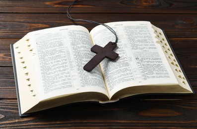 MYKOLAIV, UKRAINE - DECEMBER 21, 2021: Wooden cross and Bible on table, text in russian