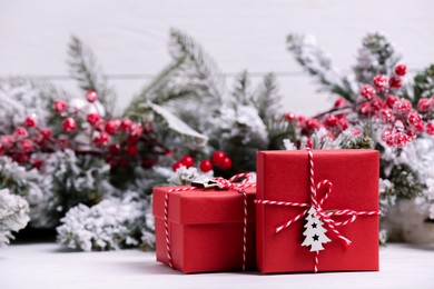Photo of Beautiful gift boxes and Christmas decor on white table. Space for text