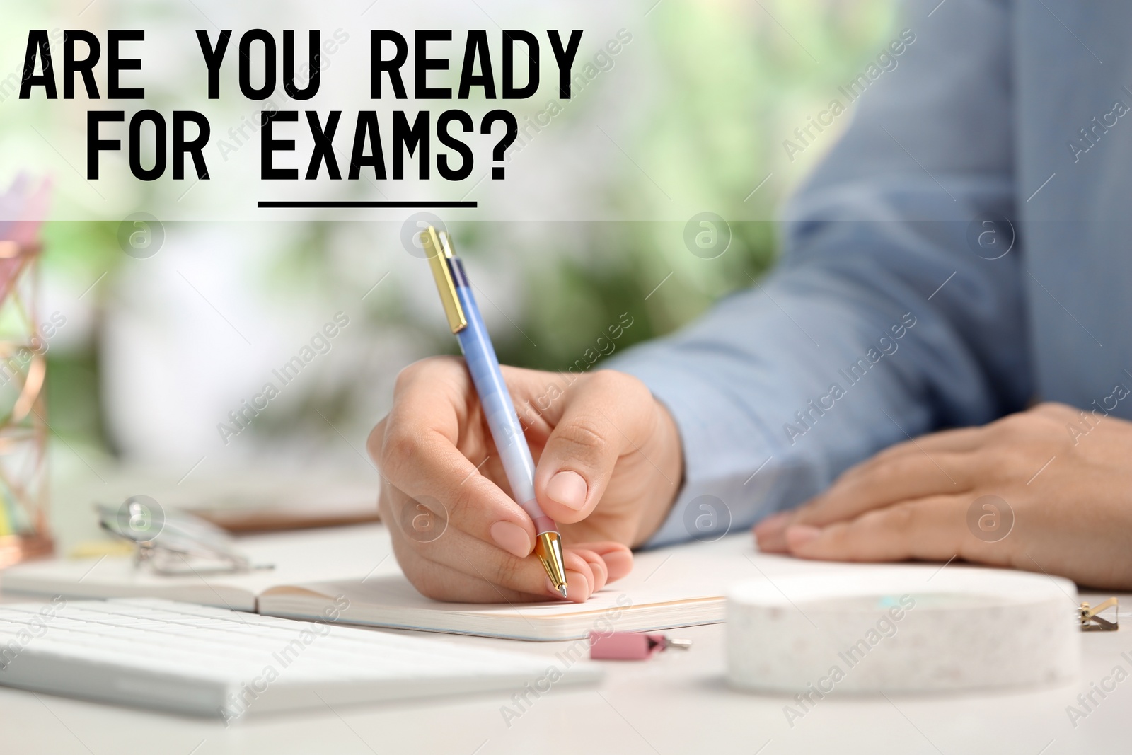 Image of Student writing examination at table indoors, closeup