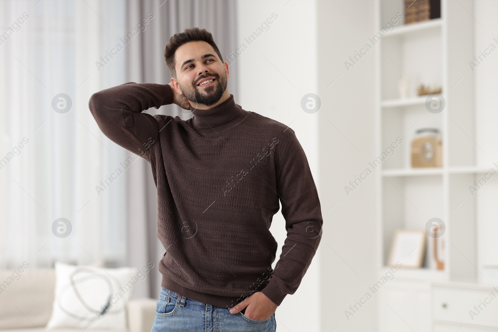 Photo of Happy man in stylish sweater at home, space for text