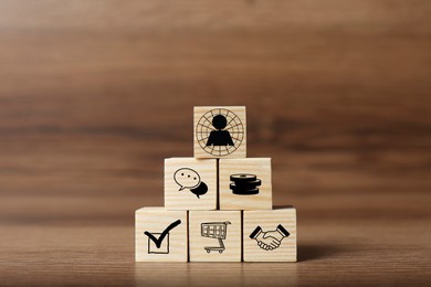 Image of Professional buyer. Cubes with different icons on wooden table