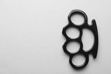 Photo of Black brass knuckles on white background, top view. Space for text