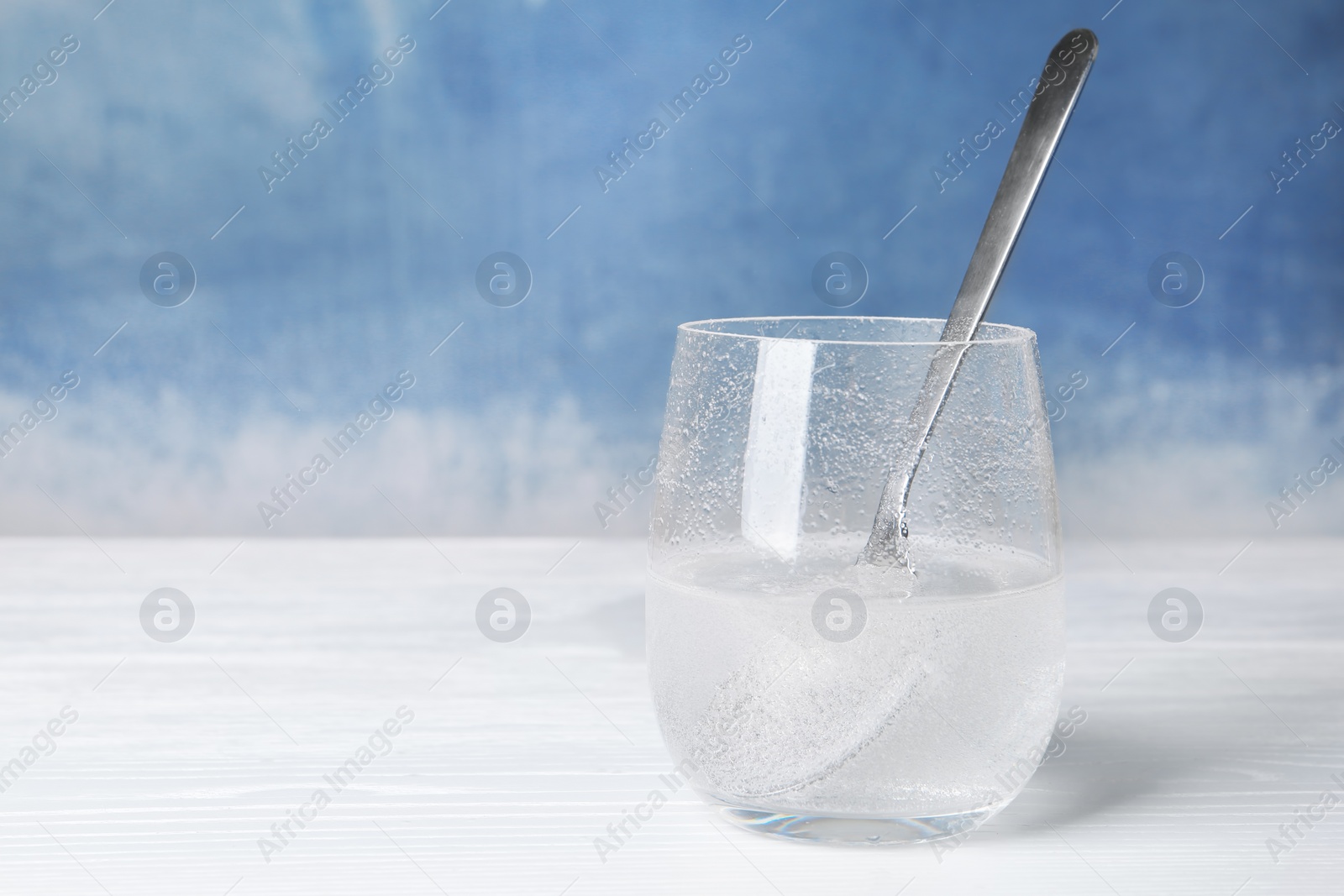 Photo of Chemical reaction of vinegar and baking soda in glass on table. Space for text