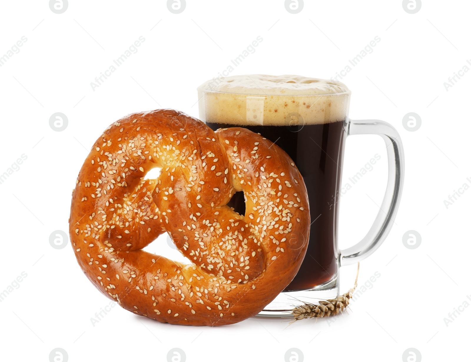 Photo of Tasty freshly baked pretzel and mug of dark beer on white background