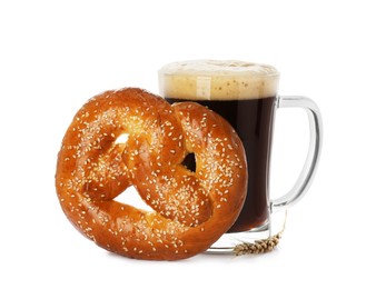 Tasty freshly baked pretzel and mug of dark beer on white background