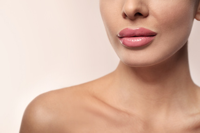 Woman with pink lipstick on light background, closeup