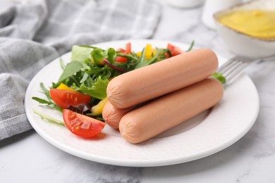 Delicious boiled sausages with salad on table