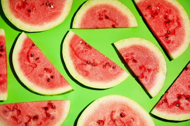 Photo of Watermelon slices on green background, flat lay