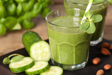 Photo of Fresh green smoothie and ingredients on wooden table, closeup