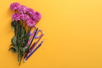 Photo of Beautiful flowers and stationery on orange background, flat lay with space for text. Teacher's Day