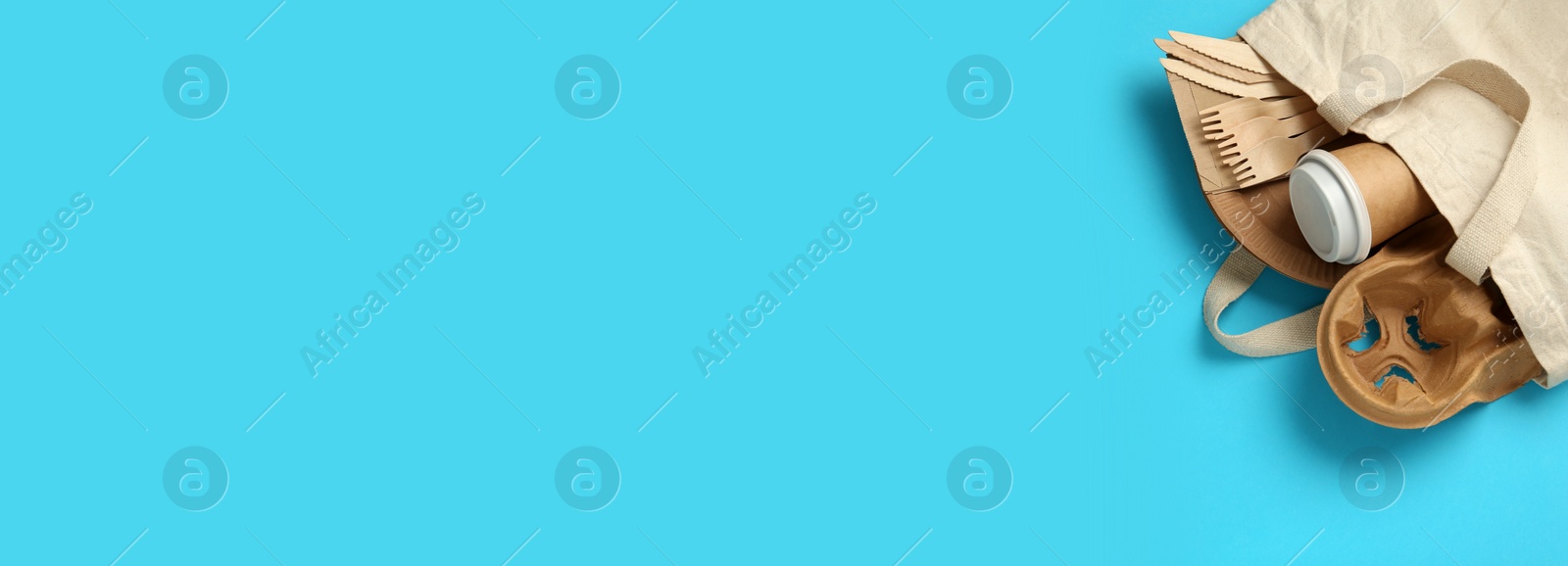 Image of Paper and wooden tableware in cotton bag on turquoise background, top view with space for text. Banner design