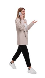 Photo of Beautiful happy businesswoman with smartphone walking on white background