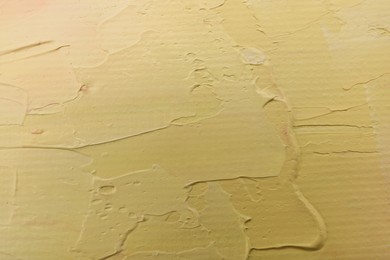 Photo of Beautiful strokes of pale yellow oil paint as background, closeup