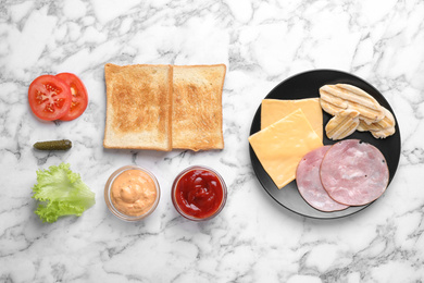 Fresh ingredients for tasty sandwich on white marble background, flat lay