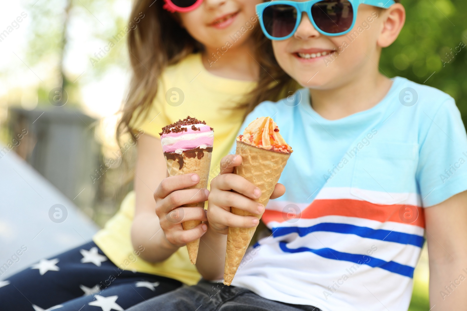 Photo of Cute little children with delicious ice creams outdoors, closeup